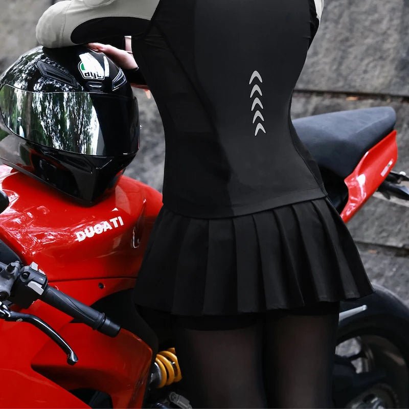 Jupette moto femme vue dos avec bandes réfléchissantes dorsales près d'une Ducati rouge